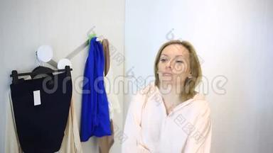 女人在服装店购物，挑选衣服，女人在更衣室试穿衣服，照镜子